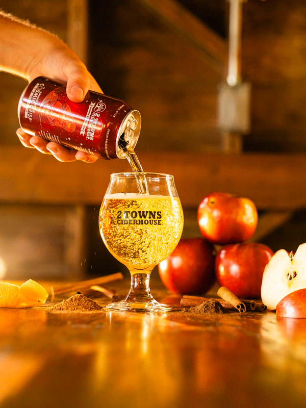 2 towns cosmic crisp cider being poured into a glass